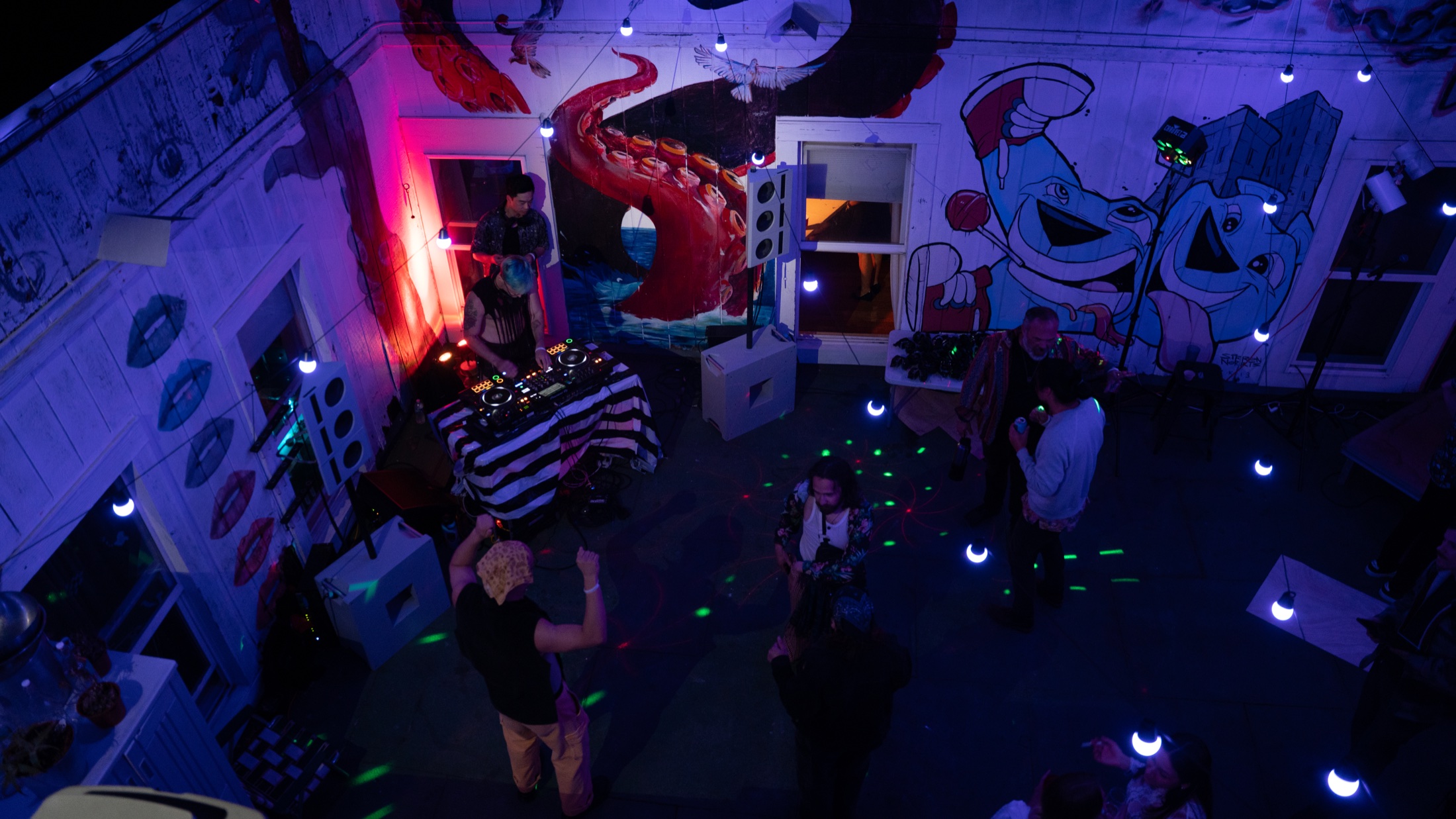 A Hi-Tone sound system supporting a DJ event in a mural-covered urban arts venue